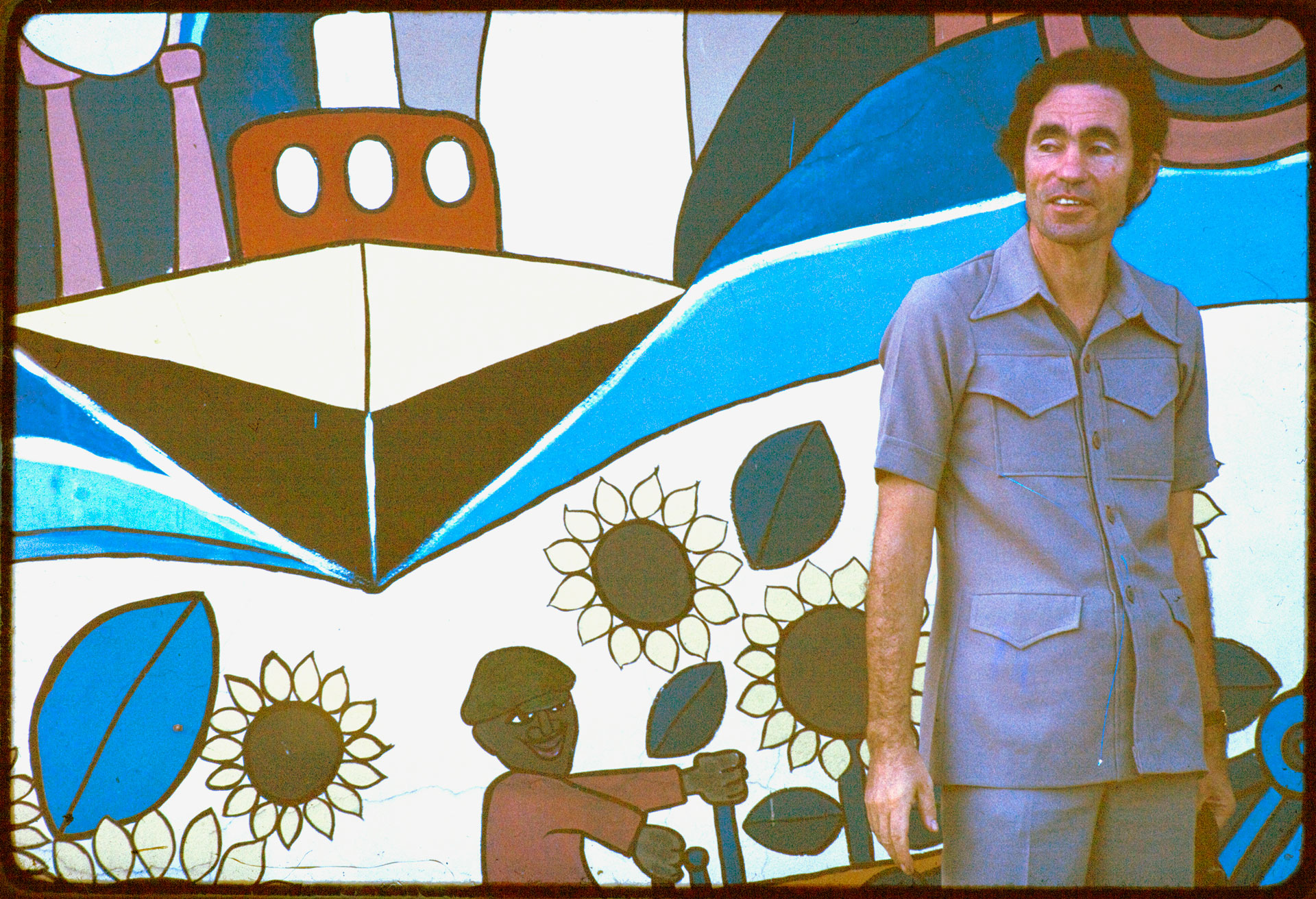 Albie in front of Maputo mural ‘A Cry of Happiness’.