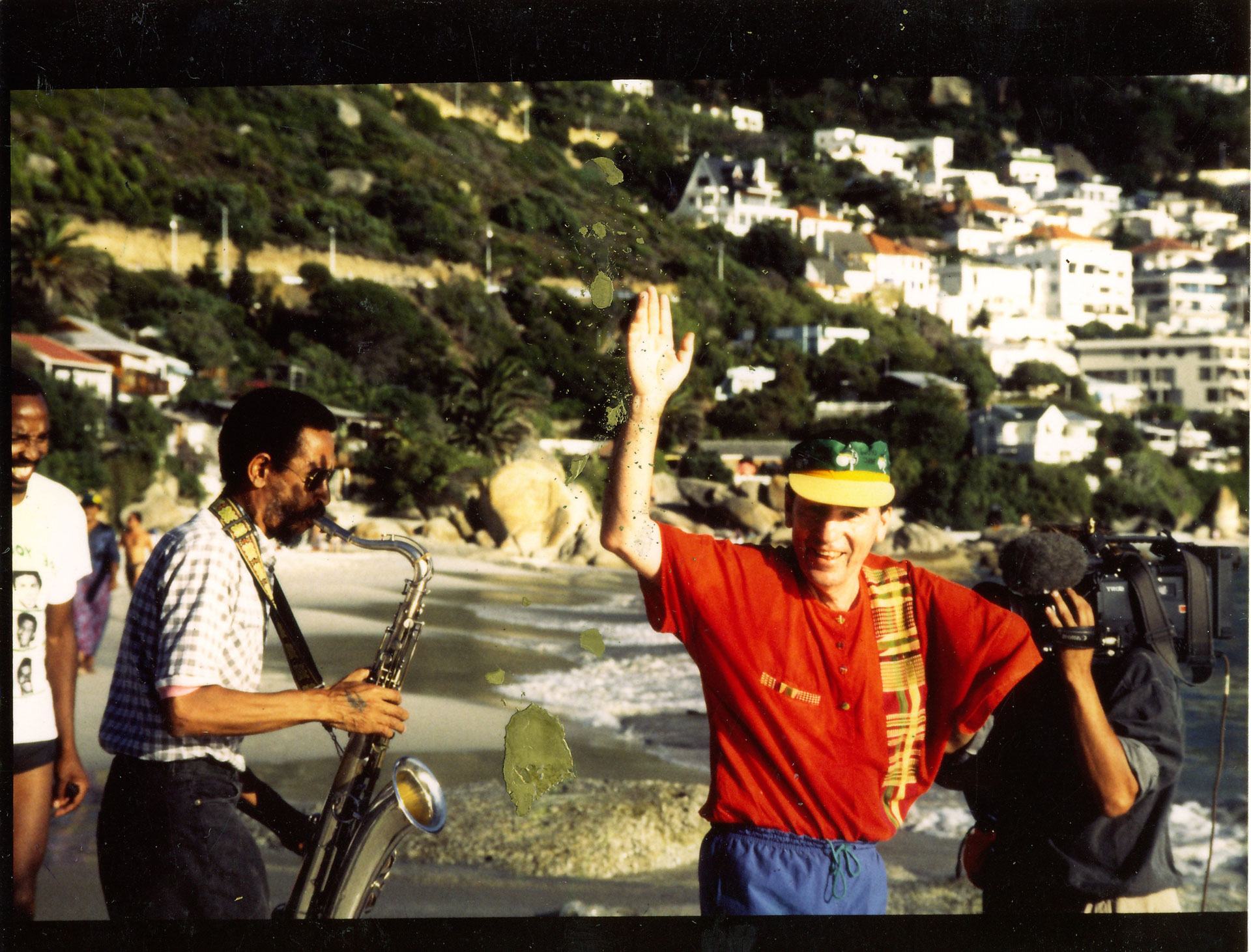 Albie repeats his run from Caledon Square Police Station to Clifton beach, 30 years after his release from his first 90-day detention in solitary confinement, and shortly before South Africa’s first democratic elections in 1994. Basil Manenberg Coetzee plays the saxaphone as Albie passes.