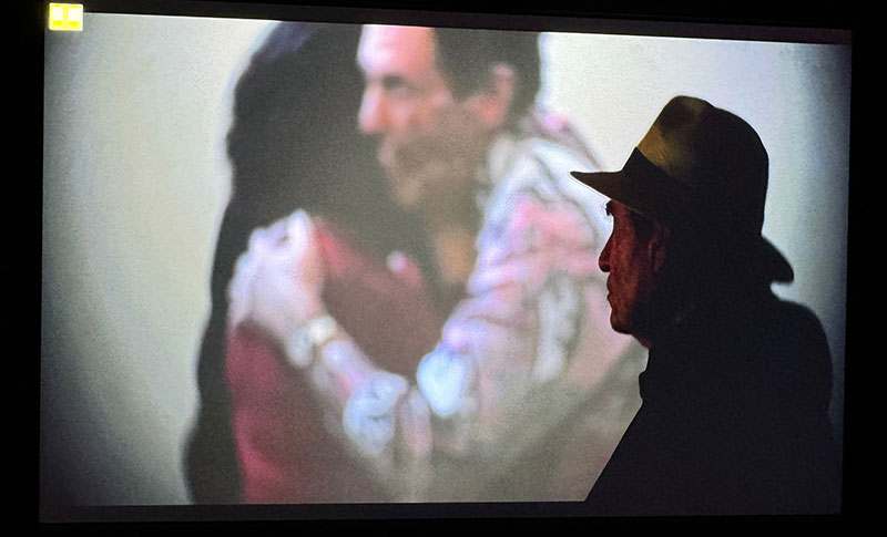Albie watching projection of video clip from wedding - hugging Vanessa